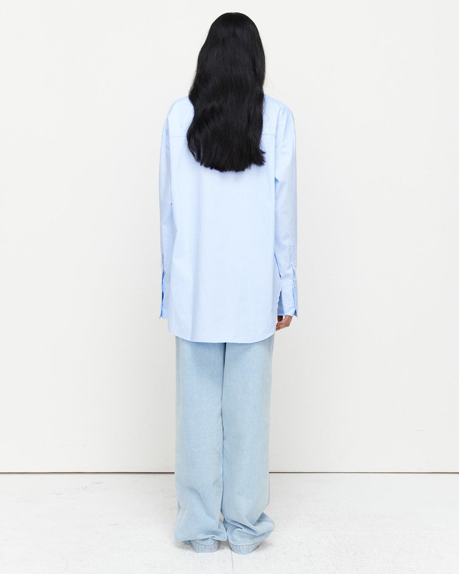The Classic Cotton Shirt is an oversized essential, crafted from 100% cotton for effortless wear. Featuring a cheeky kiss embroidery under the left collar, this piece showcases exclusive artwork in collaboration with Anouk Colantoni.
