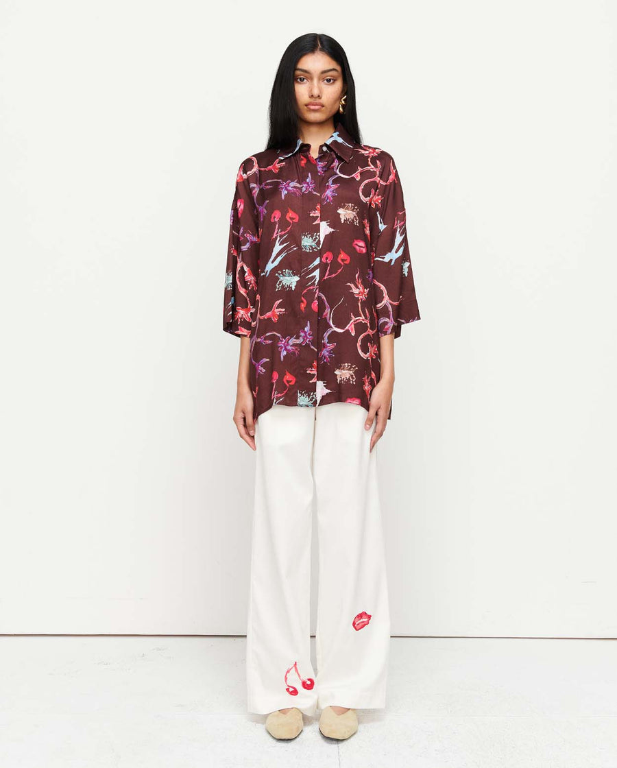 Effortlessly chic, the June Shirt features an oversized fit with short sleeves, a concealed placket, and exaggerated sleeves. Adorned with exclusive artwork in collaboration with Anouk Colantoni.