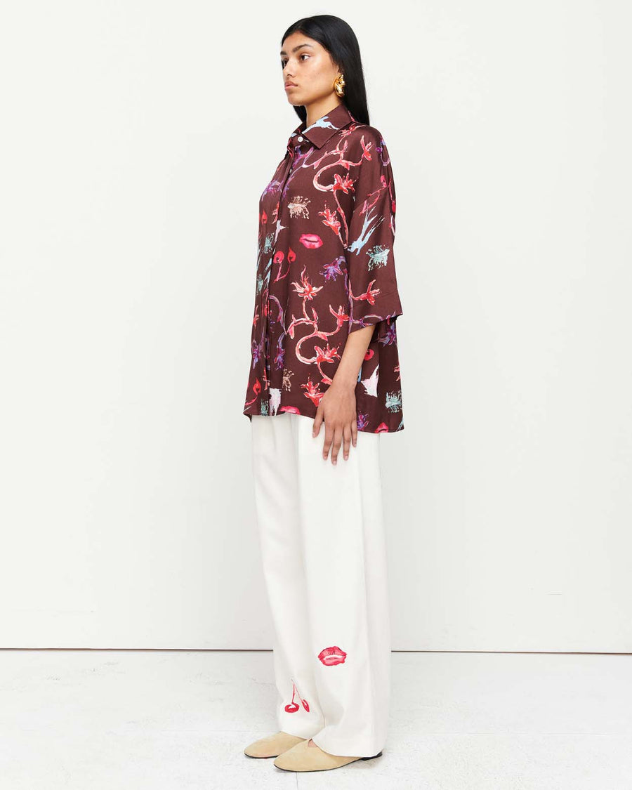 Effortlessly chic, the June Shirt features an oversized fit with short sleeves, a concealed placket, and exaggerated sleeves. Adorned with exclusive artwork in collaboration with Anouk Colantoni.