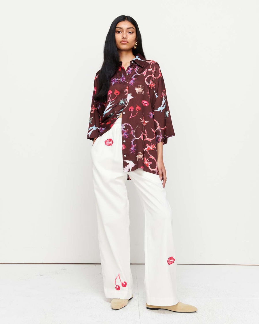 Effortlessly chic, the June Shirt features an oversized fit with short sleeves, a concealed placket, and exaggerated sleeves. Adorned with exclusive artwork in collaboration with Anouk Colantoni.
