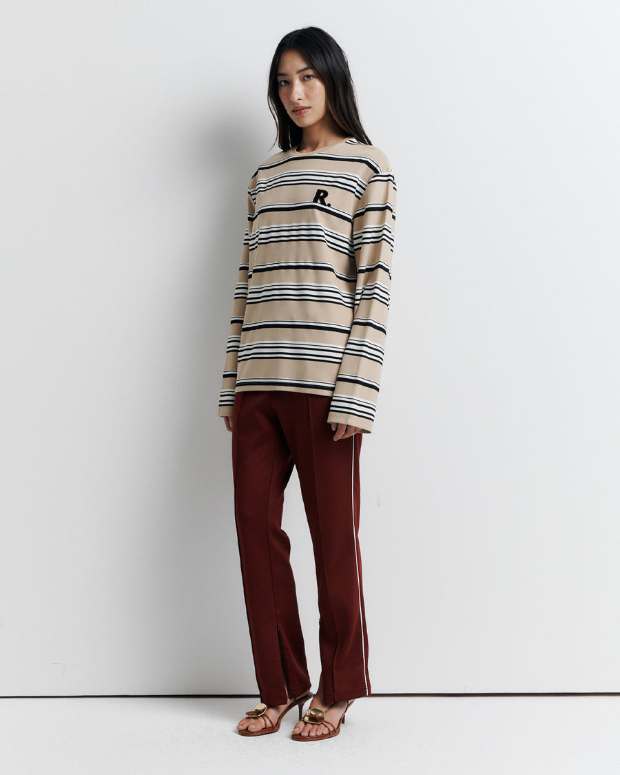 The Varsity Long Sleeve Top is a relaxed-fit striped crew neck tee, featuring long sleeves and the signature Romy Athletic Society 'R' embroidery for a sporty, elevated look.