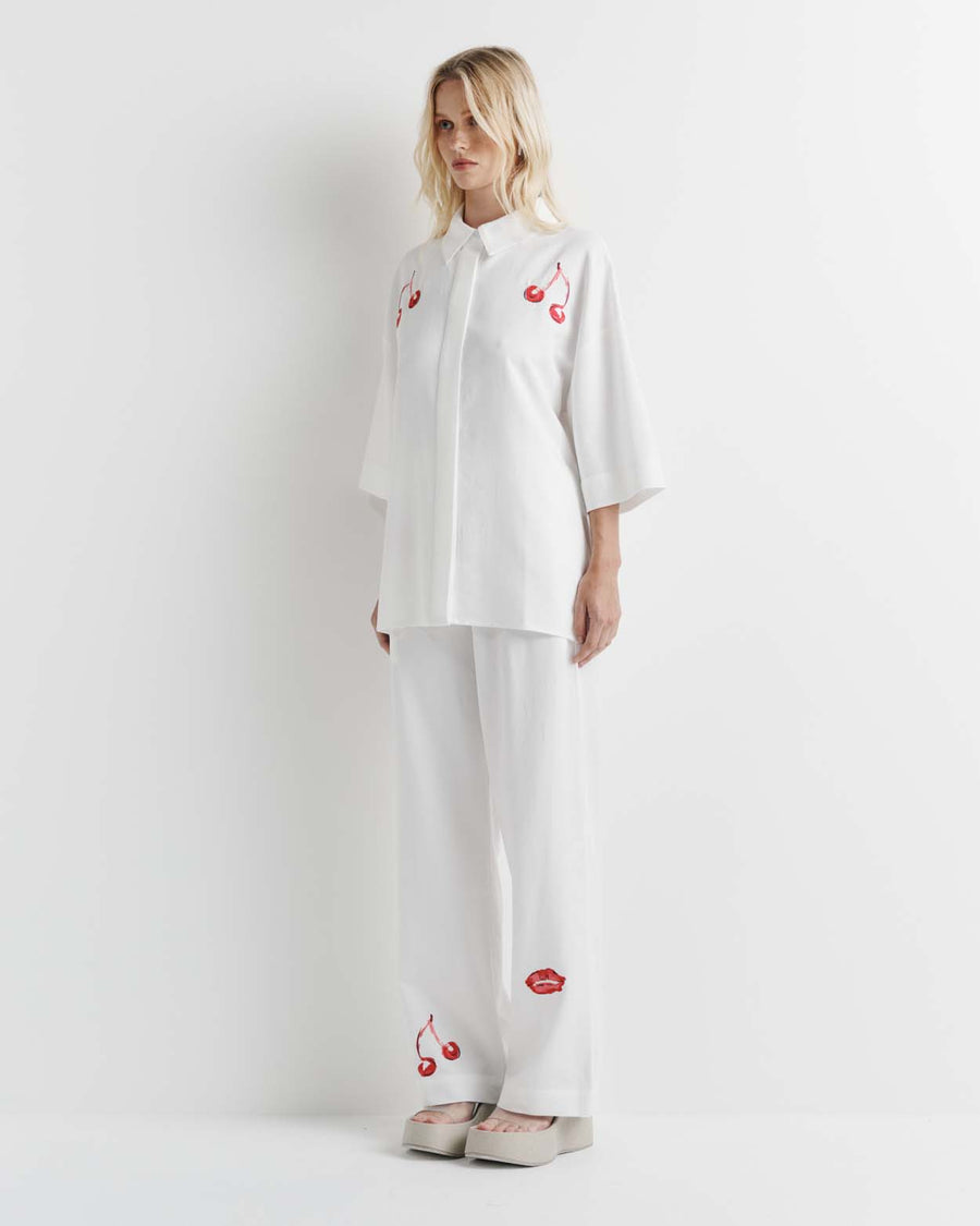 Effortlessly chic, the Cherry Shirt features an oversized fit with short sleeves, a concealed placket, and exaggerated sleeves. Adorned with exclusive artwork in collaboration with Anouk Colantoni.
