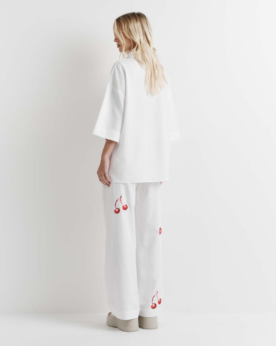 Effortlessly chic, the Cherry Shirt features an oversized fit with short sleeves, a concealed placket, and exaggerated sleeves. Adorned with exclusive artwork in collaboration with Anouk Colantoni.