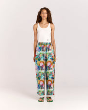 Upgrade your summer wardrobe with the Vibescent Pant, crafted from a matte twill blend of viscose and recycled rayon featuring exclusive artwork by Jake Pedro. These playful pants boast an elastic waistband, a self-tie adorned with gold beads, and convenient side pockets, offering effortless style and comfort for any occasion.