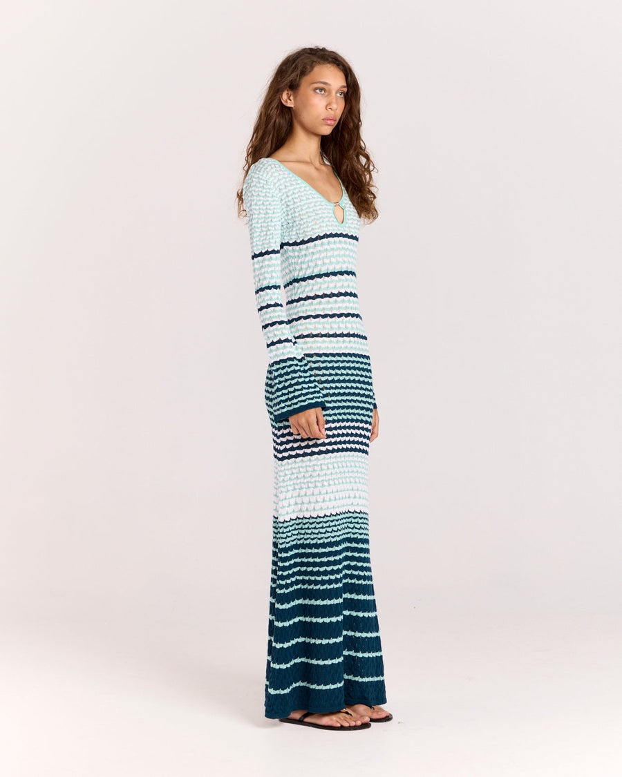 Discover the Havana Dress, a long fitted style crafted from soft pointelle Tencel knit with a crochet-inspired texture. Featuring a deep round neckline, keyhole opening, and gold button accents, this unlined dress offers a sleek, figure-hugging silhouette with long sleeves and a straight hem.